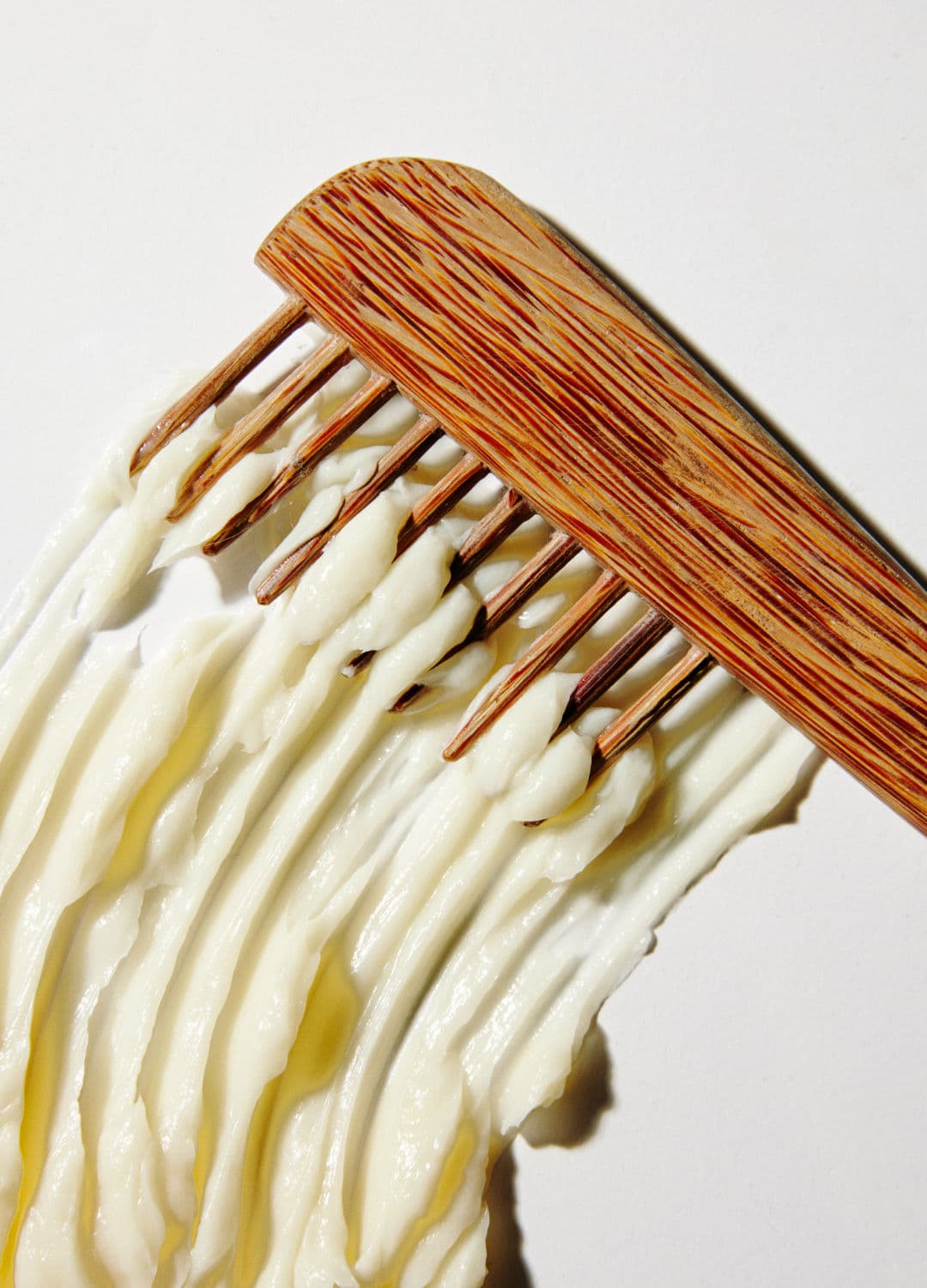 Wooden comb with cream hair mask texture